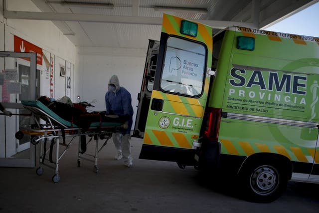 Trabajadores de la salud llevan a un paciente en camilla a un hospital para enfermos de COVID-19 en Mar del Plata, Argentina.