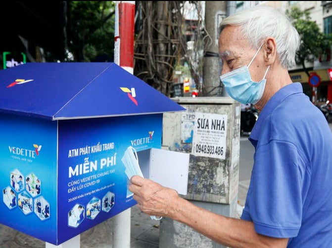 In Vietnam, masks are being distributed for free using both specially designed ATMs and simple boxes, such as this one in Hanoi