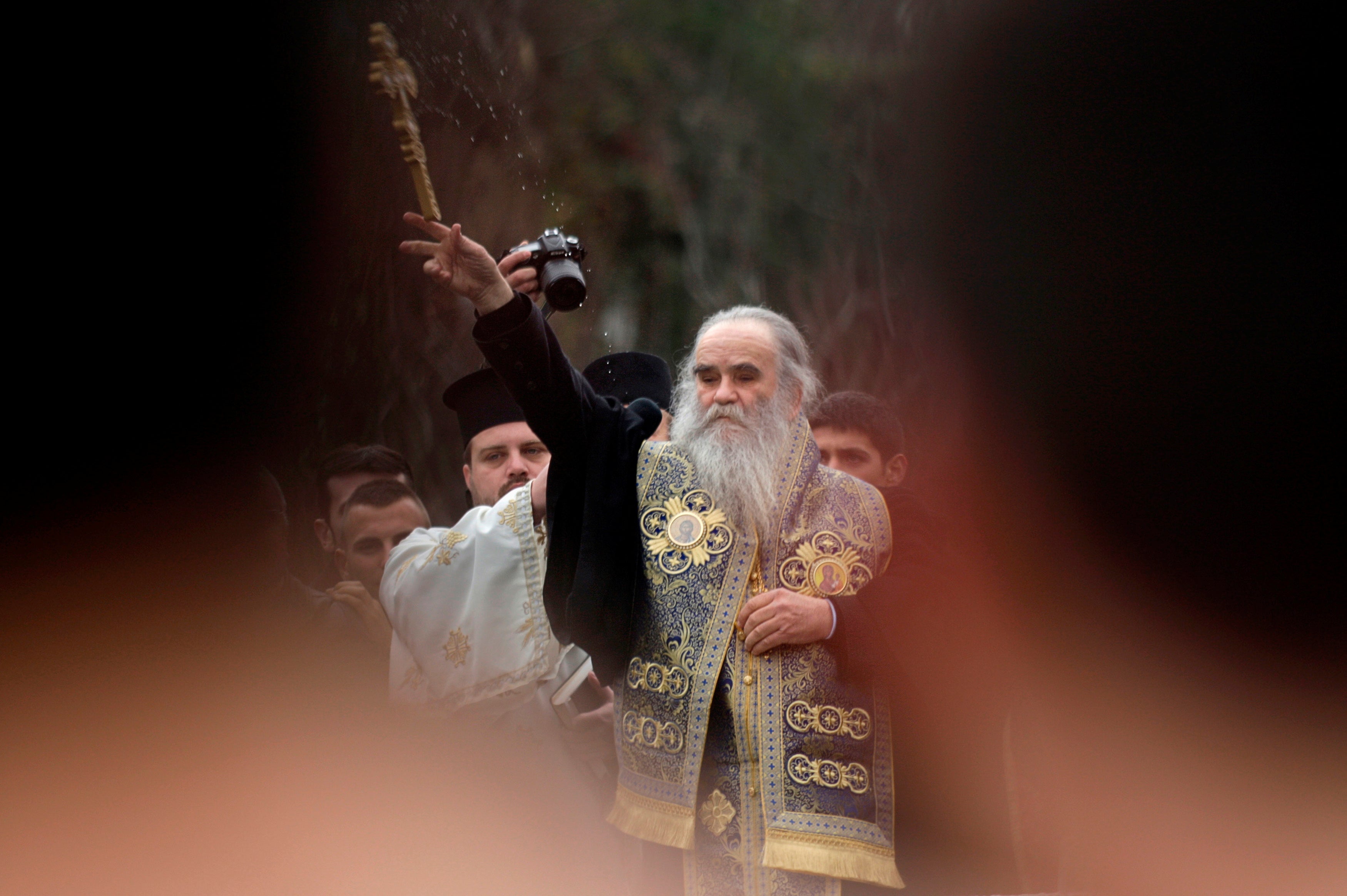 Metropolitan Amfilohije Radovic throws a wooden cross in a river Ribnica during Epiphany Day celebrations (REUTERS//File Photo)