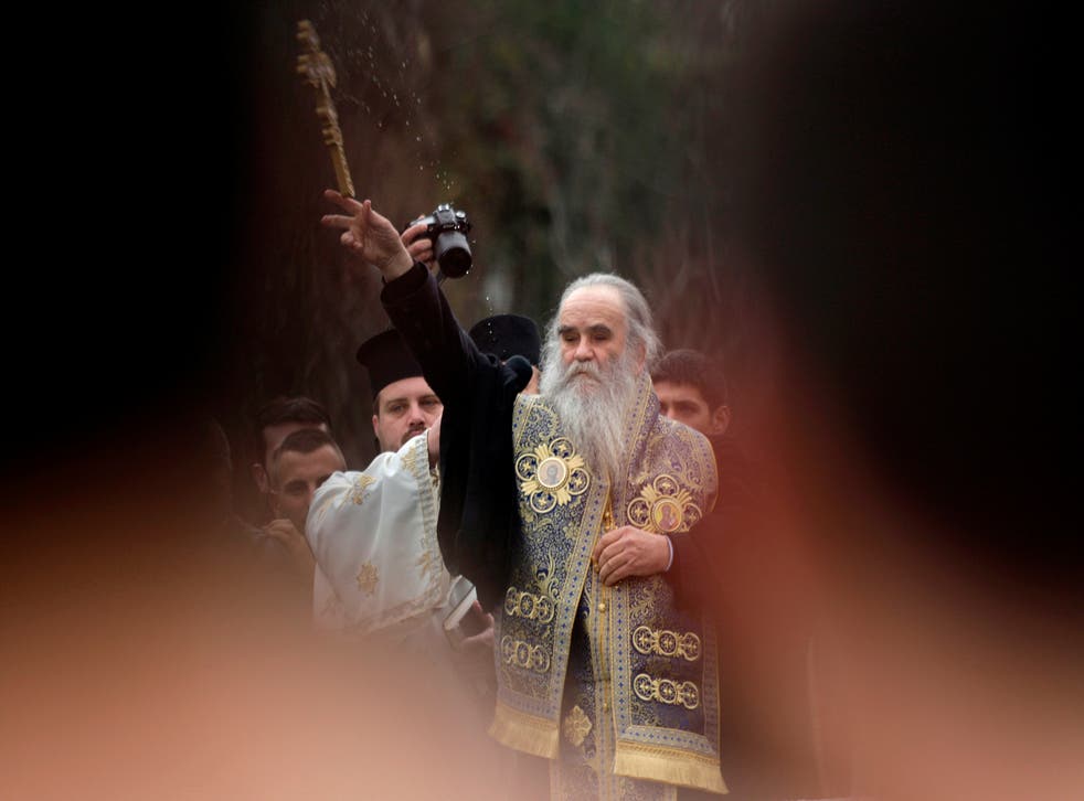 Metropolitan Amfilohije Radovic throws a wooden cross in a river Ribnica during Epiphany Day celebrations (REUTERS//File Photo)