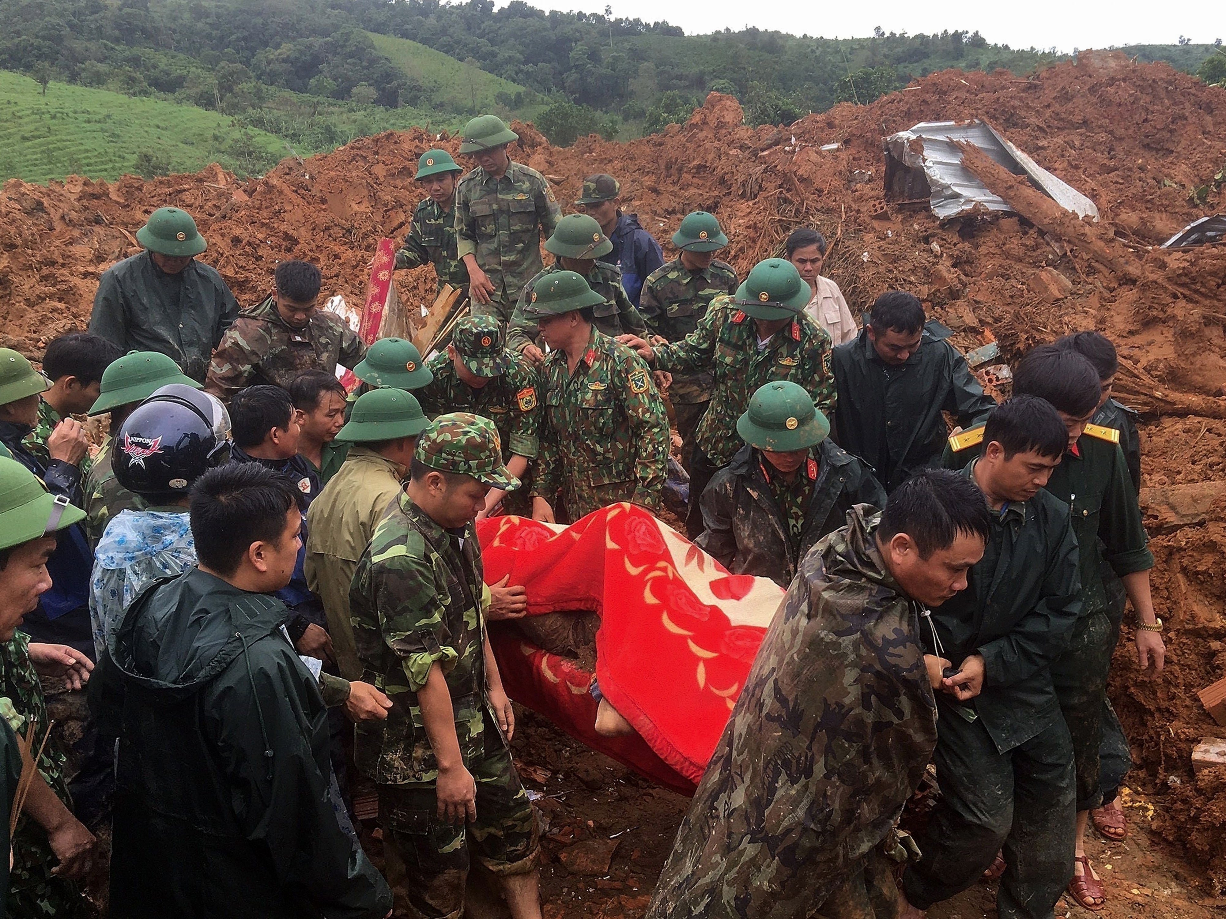 Military personnel carry a body recovered from the site in central Vietnam’s Quang Tri province