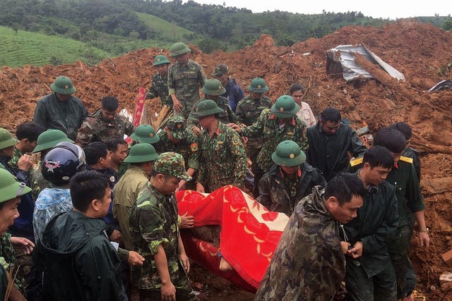 Military personnel carry a body recovered from the site in central Vietnam’s Quang Tri province