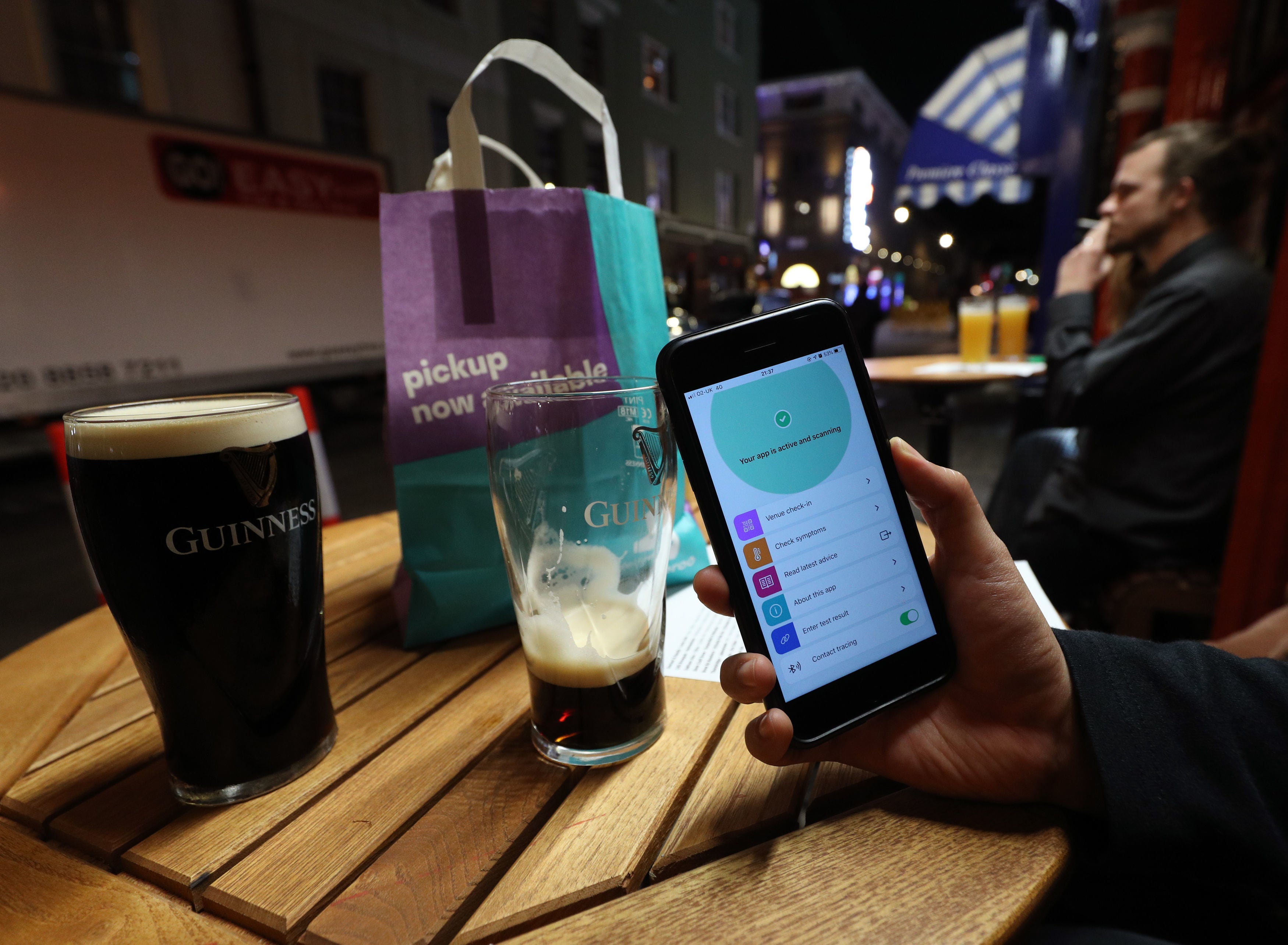 A person uses the NHS coronavirus contact tracing app outside The Coach and Horses pub in Soho, central London