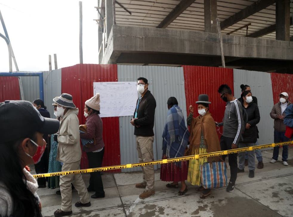 Personas hacen fila afuera de un colegio electoral para votar durante las elecciones generales en La Paz, Bolivia, el domingo 18 de octubre de 2020. (Foto/Juan Karita)