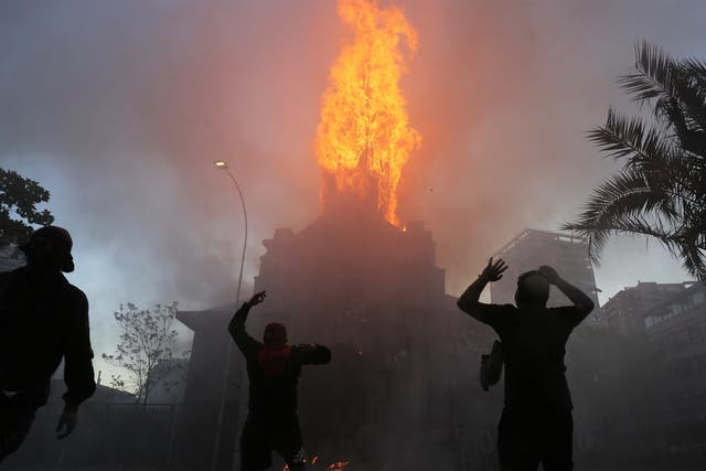 Firefighters working to extinguish fire in the aftermath of a protest in Santiago, 18 October 2020