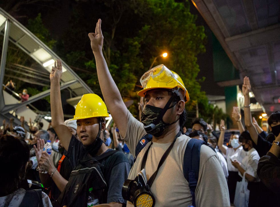 Thai pro-democracy protesters hold up a three finger salute at a rally in Bangkok on Monday