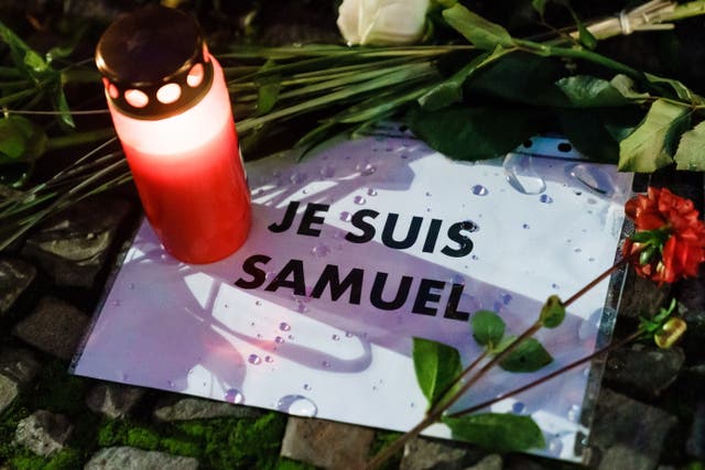 A candle and message placed at the site of a vigil to pay respect to beheaded French teacher Samuel Paty in front of the French embassy, in Berlin