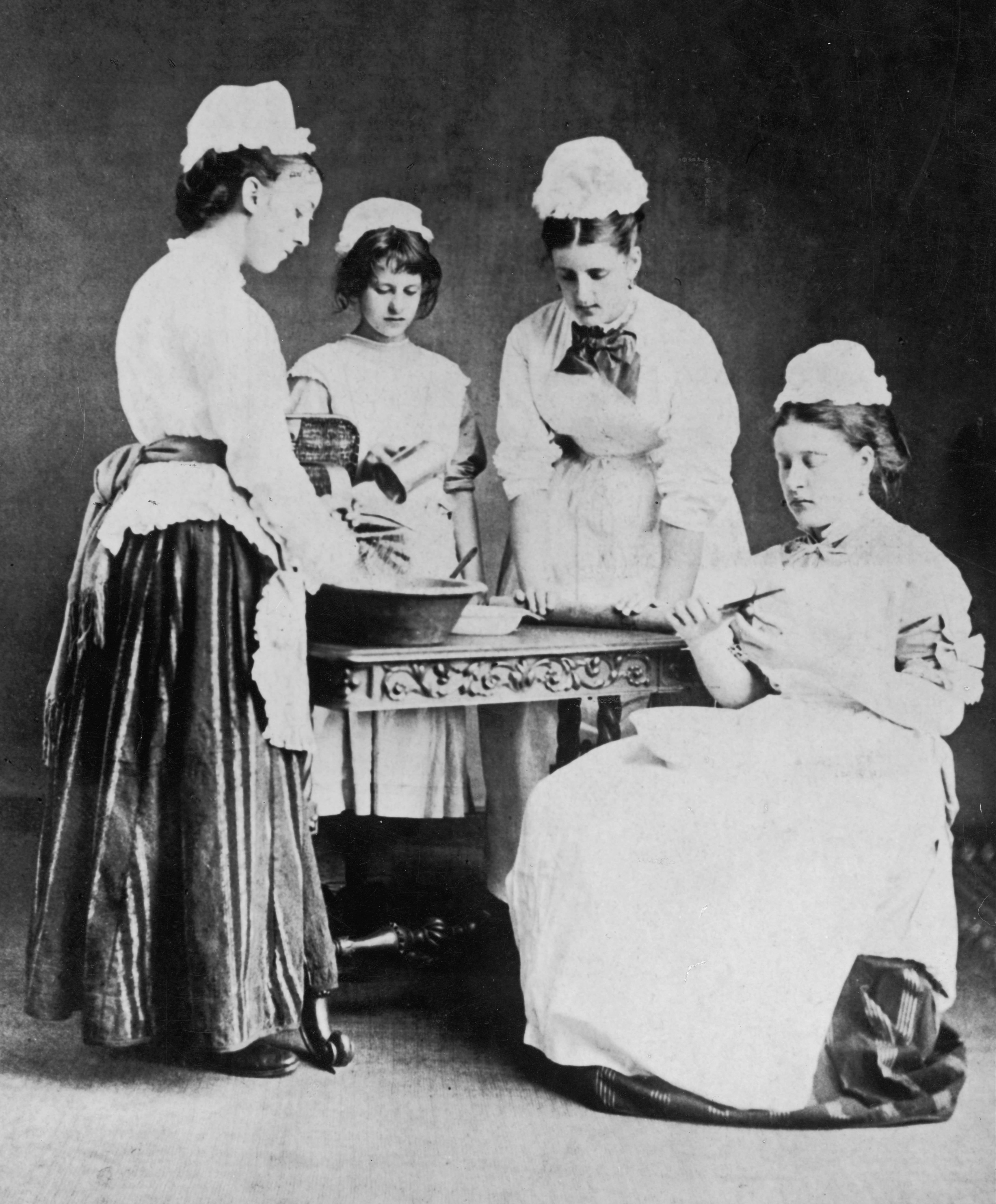 When the help lived below stairs ... Maids at work round a table in the kitchen of a house in Keswick, Cumbria, circa 1870