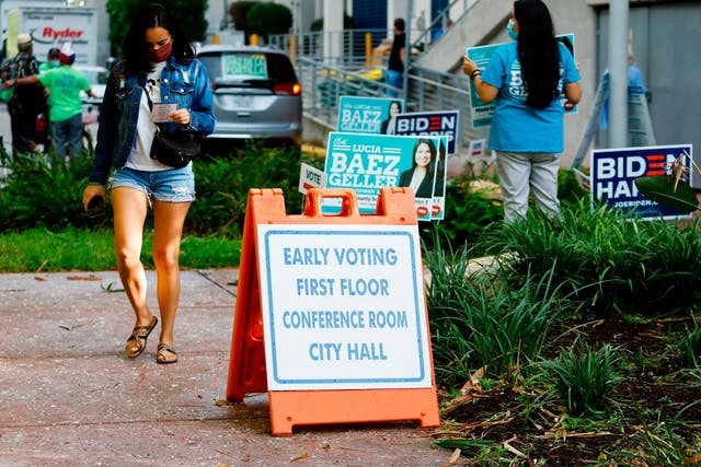 A woman walks past an Early Voting sign at Miami Beach City Hall in Miami Beach, Florida, where voting records have just been broken