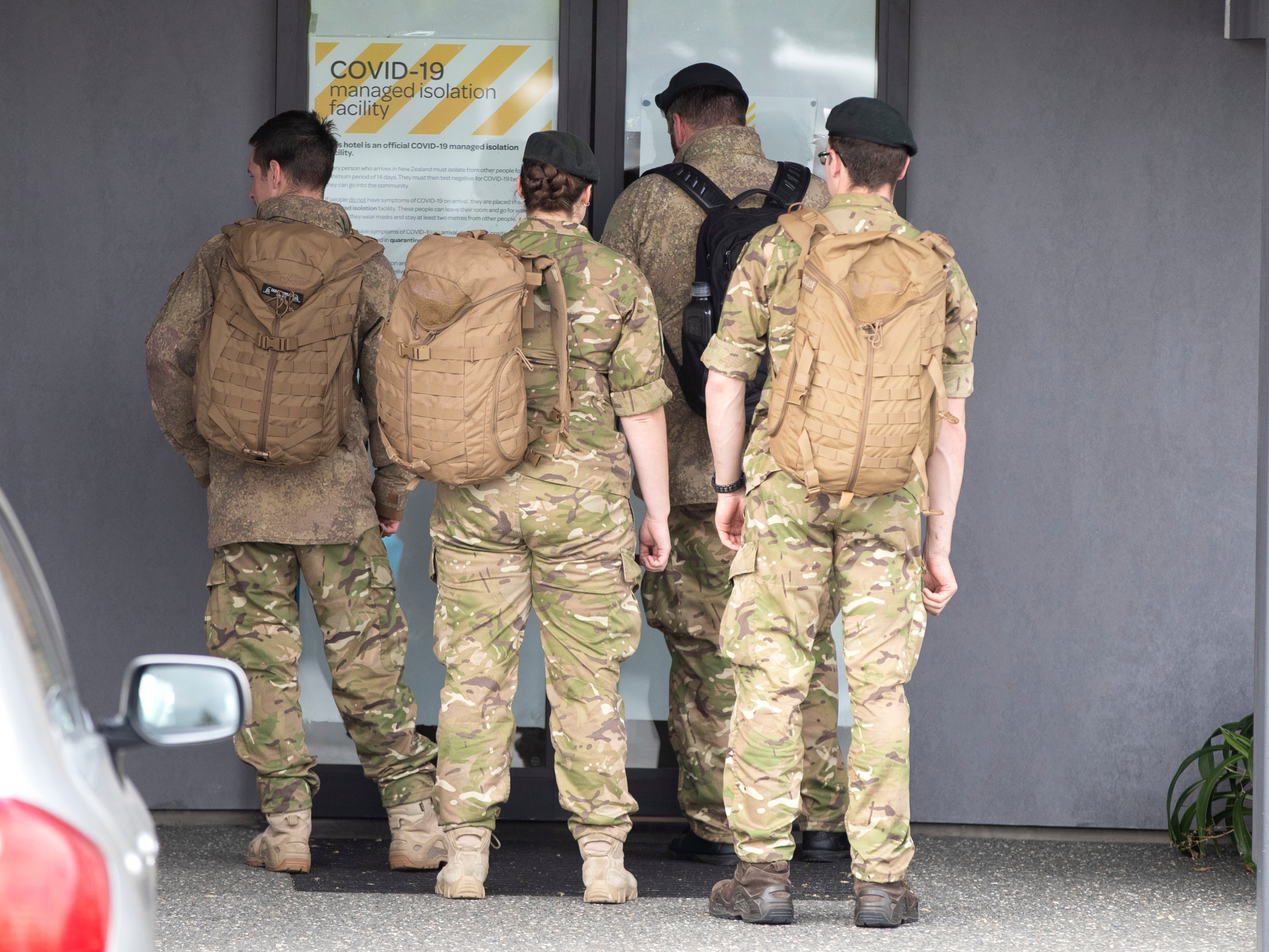 Military personnel arrive at the Sudima Hotel in Christchurch, New Zealand, after fishermen tested positive for Covid
