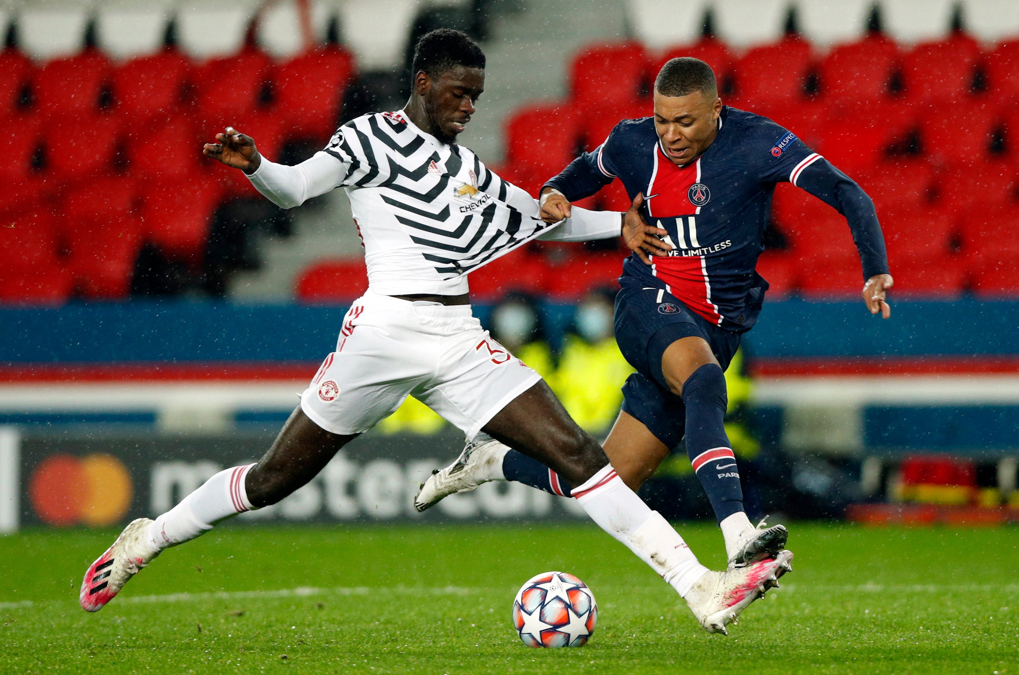 Axel Tuanzebe shields the ball from Kylian Mbappe