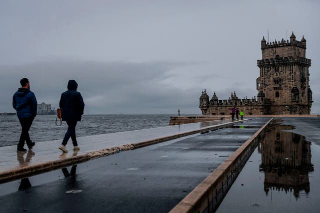 People walk along the Tagus River in Belem, Portugal, during storm Barbara on 20 October, 2020. 