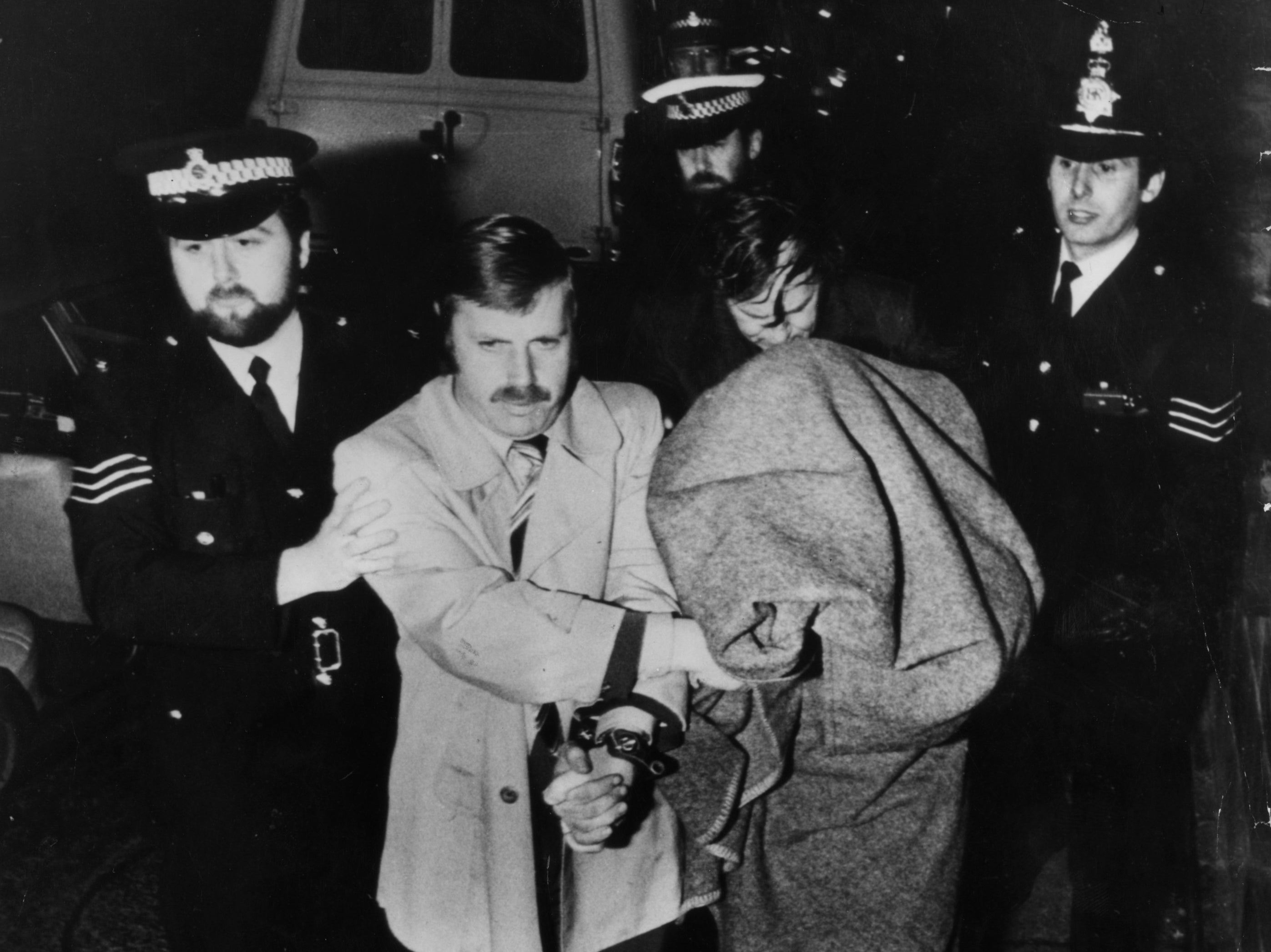 Peter Sutcliffe, aka The Yorkshire Ripper, is brought into Dewsbury Court under a blanket