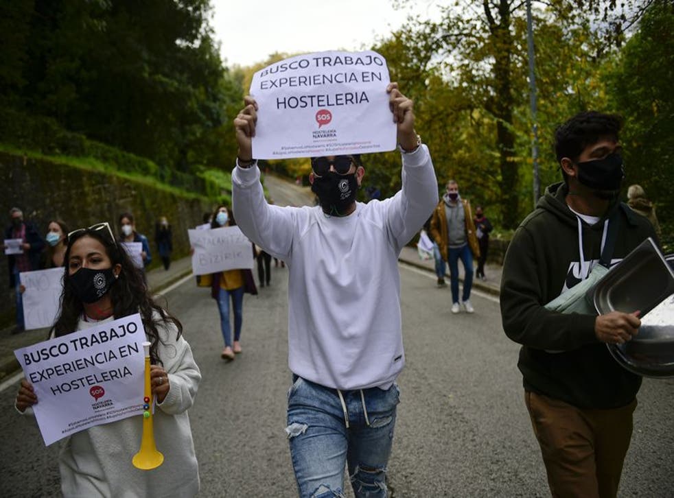 Gente alza pancartas en apoyo al sector hotelero en Pamplona, España.