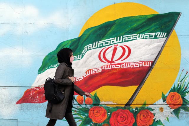 Iranian woman wearing a face mask walks next to Iranian national flag wall painting in Tehran, Iran, 19 October 2020. According to the Iranian Health ministry, Iran reported its highest daily COVID-19 death toll of 337 and 4,251 new infections in past 24 hours as it appears that Iran is in a third wave of COVID-19 outbreak.  EPA/ABEDIN TAHERKENAREH
