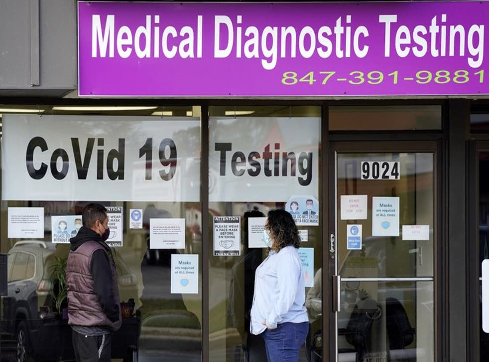 Una empleada de Exam Corp Lab habla con un paciente formado para realizarse una prueba de COVID-19 en Niles, Illinois, el miércoles 21 de octubre de 2020. (Foto/Nam Y. Huh)