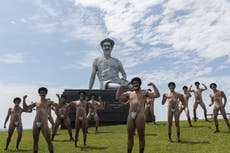 Borat statue air-lifted into Sydney, surrounded by mankini-clad men