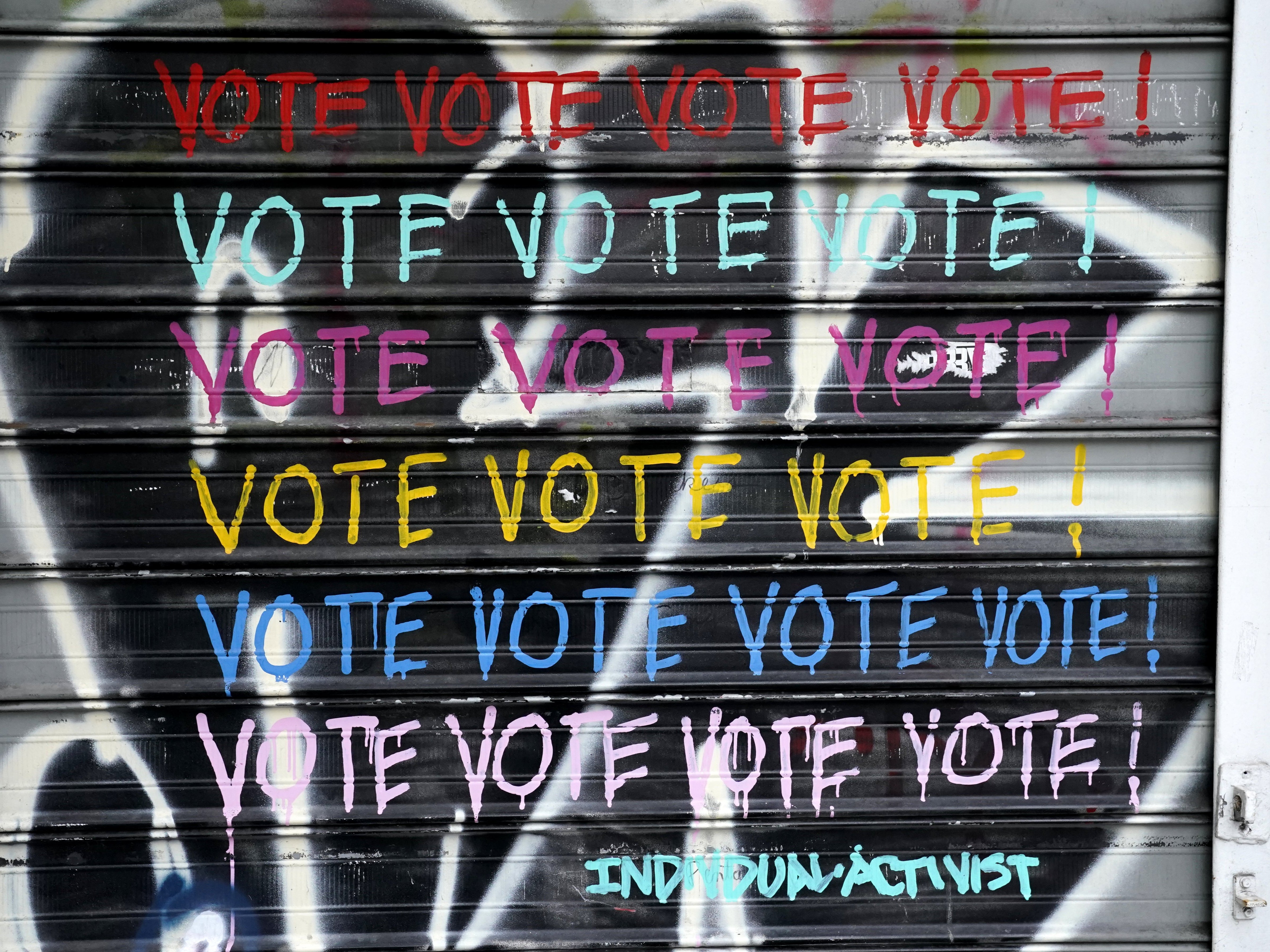 A vote mural on a store front grate is seen on Houston Street in New York City on 20 October 2020
