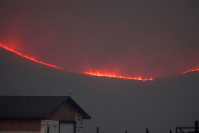 Flames rise from mountain ridges as a wildfire burns, 22 October 2020