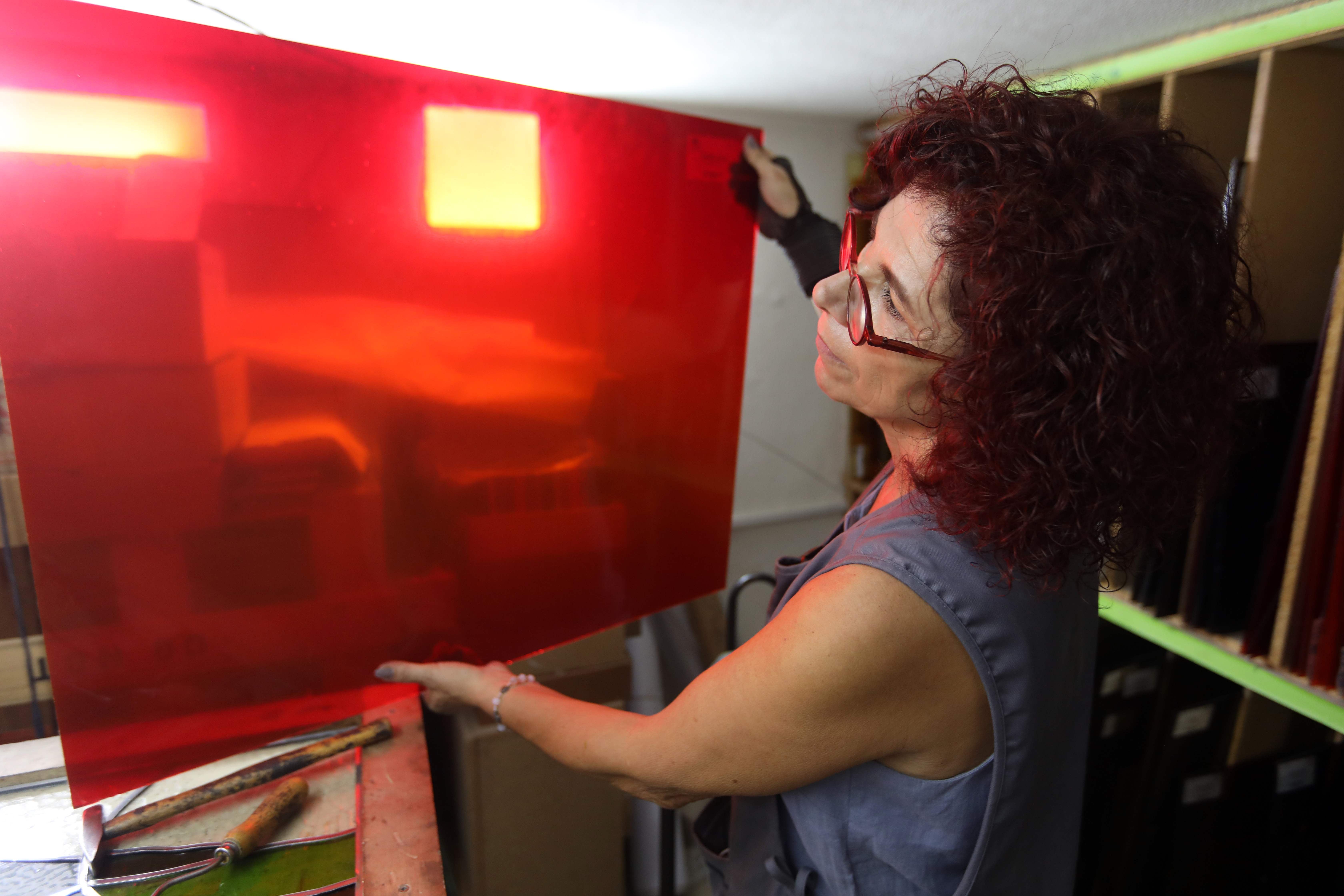 Maya Husseini examines red glass to be used on one of her works in progress