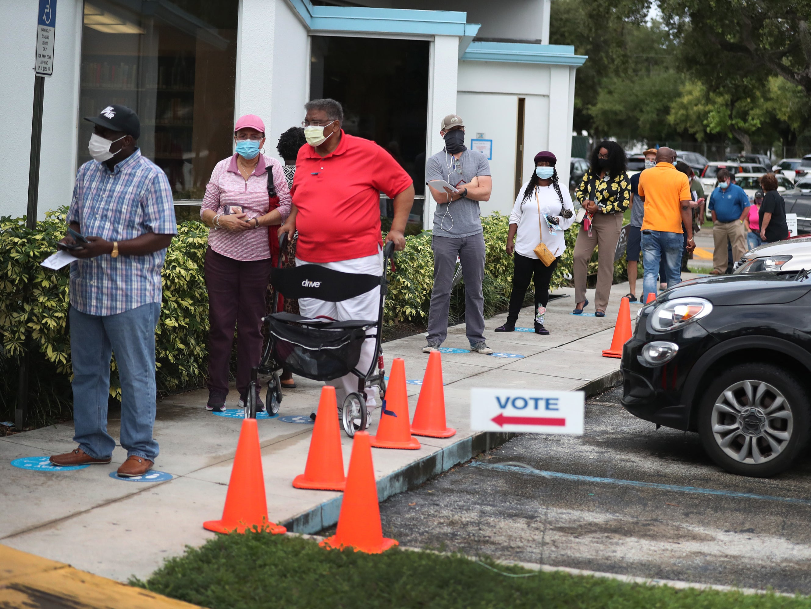 Voters wait in line to cast their early ballots at the Lemon City Branch Library precinct in Miami, Florida
