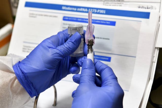 Enfermera prepara una inyección que es parte de una posible vacuna contra el COVID-19.