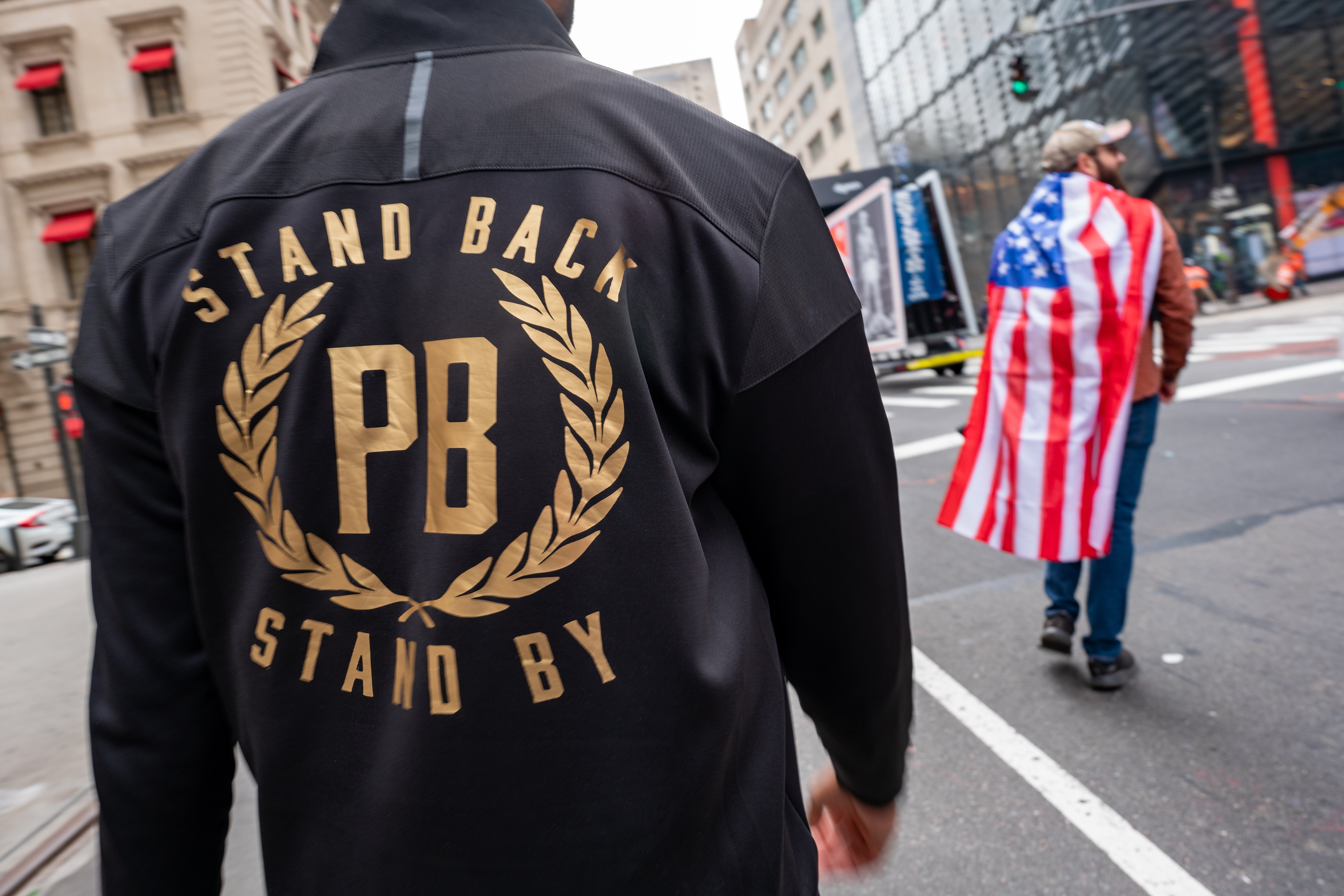 A member of the Proud Boys is pictured wearing a jacket that reads Stand Back Stand By during a march and rally for Donald Trump in New York City in October 2020