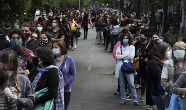 La gente hace fila y espera su turno para votar durante un plebiscito que decidirá si el país sudamericano reemplaza su constitución de 40 años, en Santiago de Chile, el domingo 25 de octubre de 2020 (Foto/Esteban Félix).