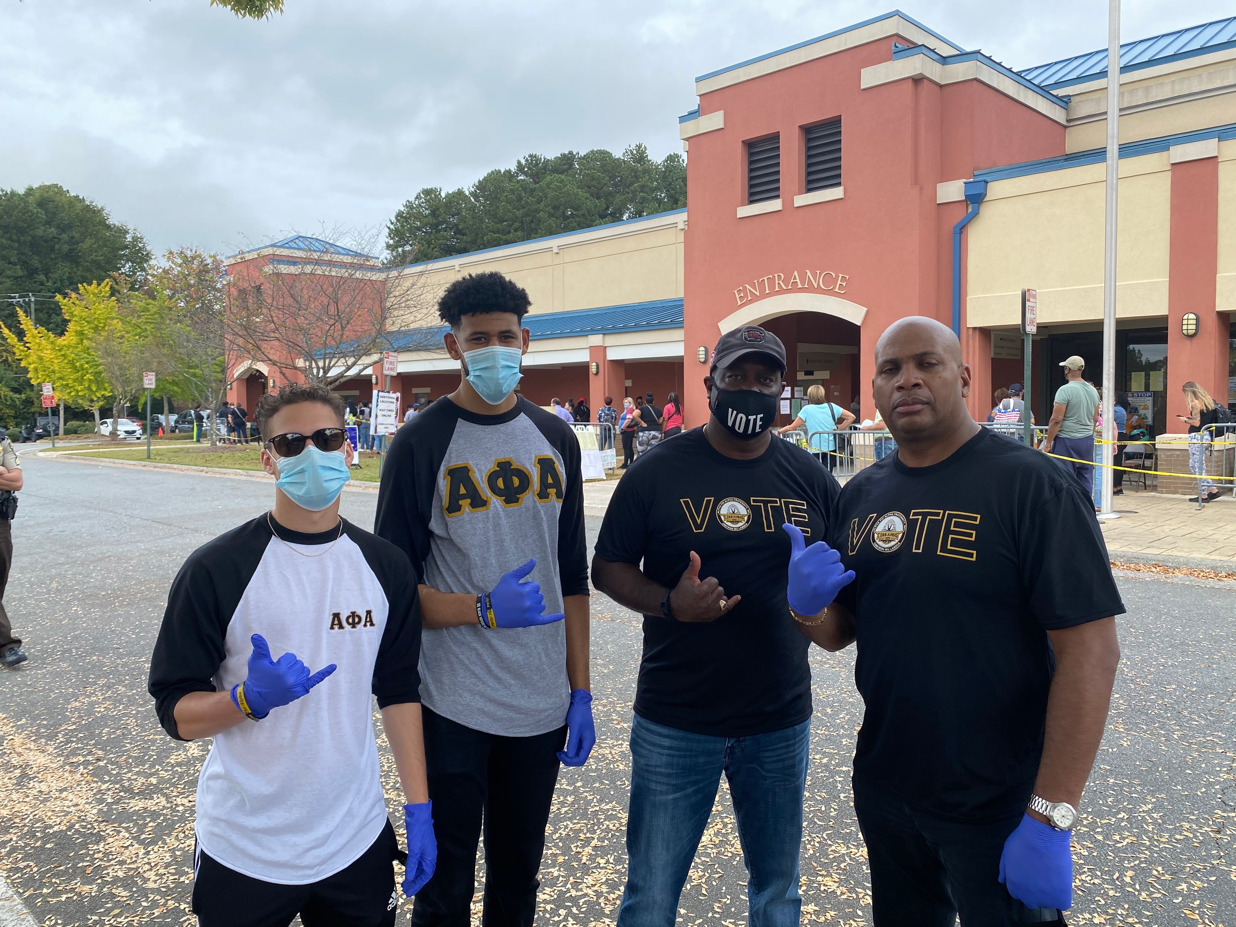 Anthony Lagroon (right) and fellow members of the Cobb Alpha fraternity, on hand to help voters in Marietta, Georgia