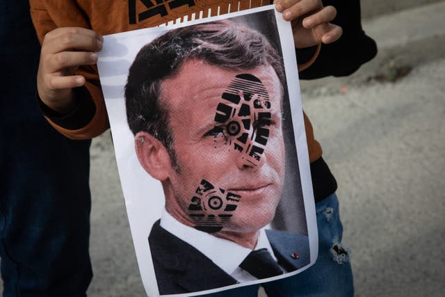 A protester holds up an image of Emmanuel Macron during demonstrations in Istanbul on Sunday