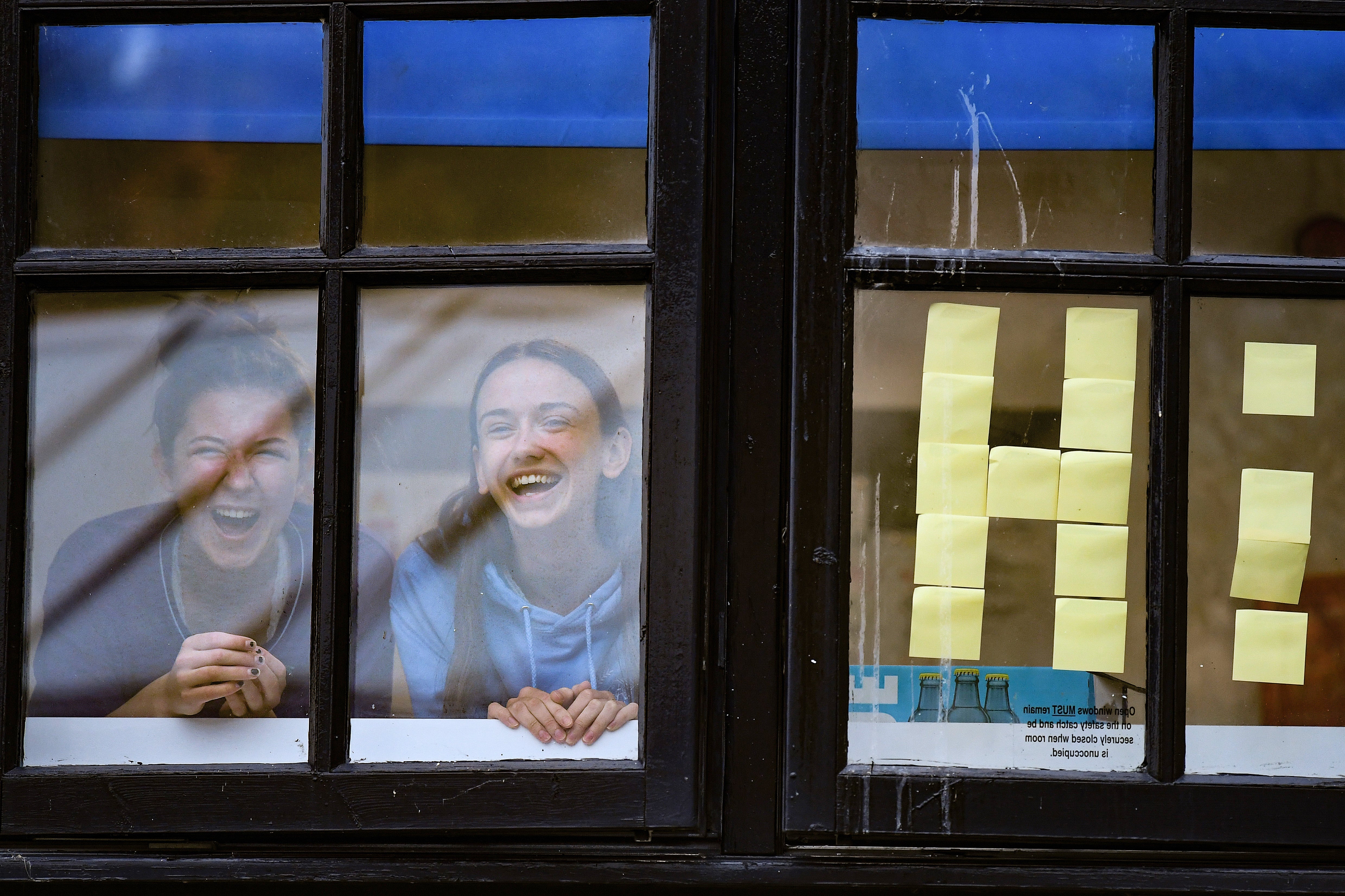 Students from Glasgow University look out of the windows of the student accommodation at Murano Street student village