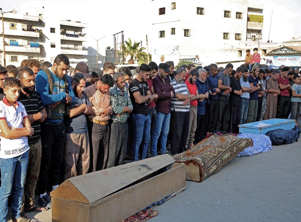 Syrians take part in the funeral of 10 fighters with the Turkey-backed Faylaq al-Sham rebel faction in Syria, in Idlib, on October 26, 2020, following their death in a Russian air strike.  (Photo by MOHAMMED AL-RIFAI/AFP via Getty Images)