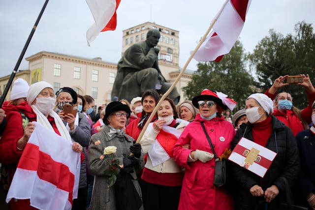 Old Belarusian flags are brandished by demonstrators in Minsk, Russia,  protesting the Belarus presidential election results, on 26 October 2020