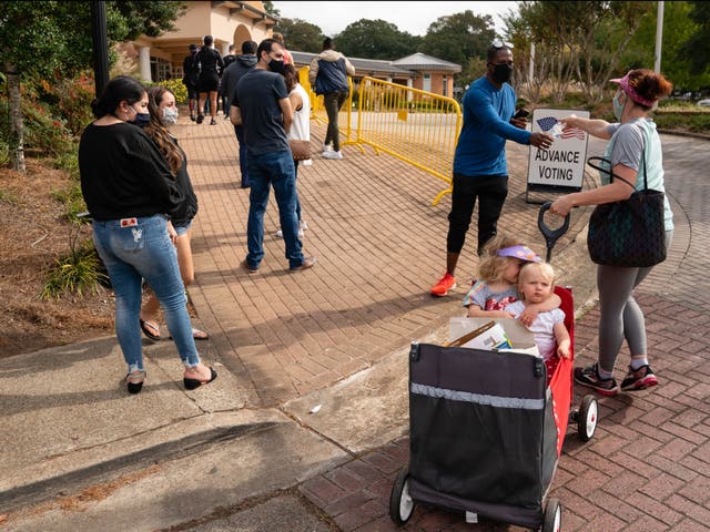 A woman hands out water to queueing voters in Georgia, showing the huge diversity of ages who could be effected should gun-toting voters turn up to polling stations