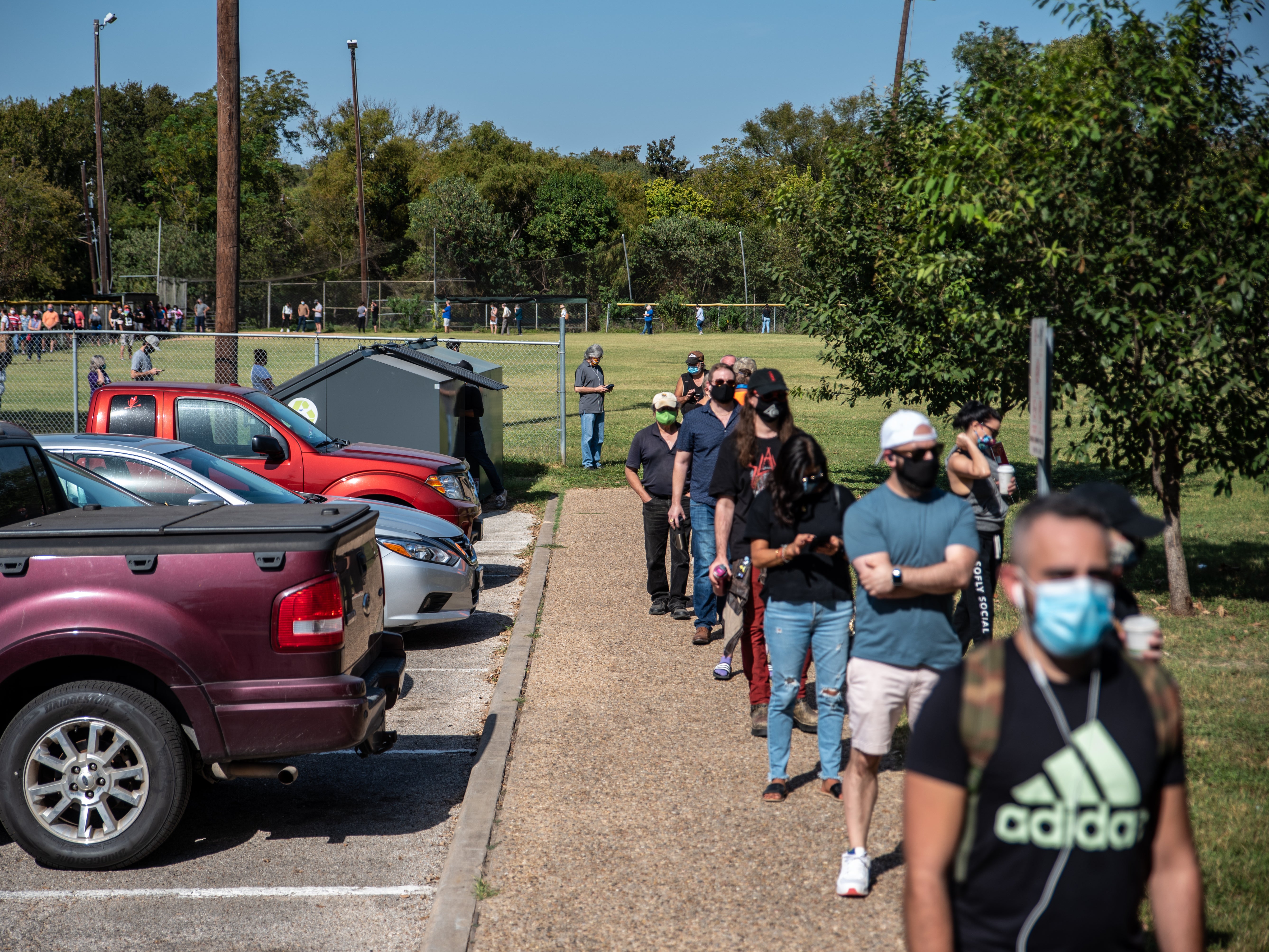 Early voters wait in line at a polling location on 13 October in Austin, Texas