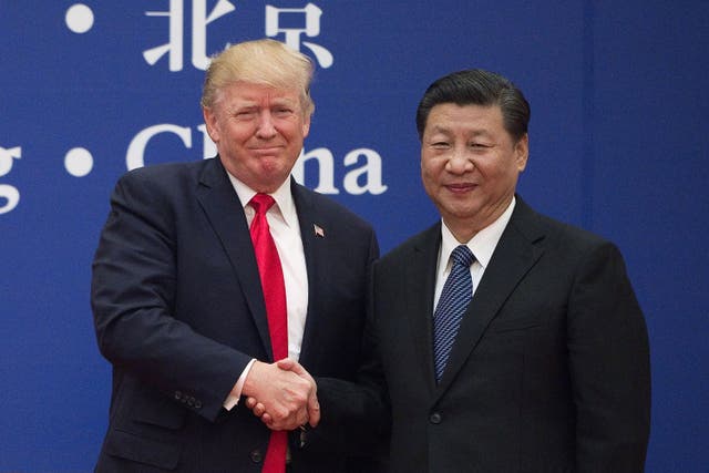 Donald Trump and Xi Jinping shake hands during an event in Beijing, 2017