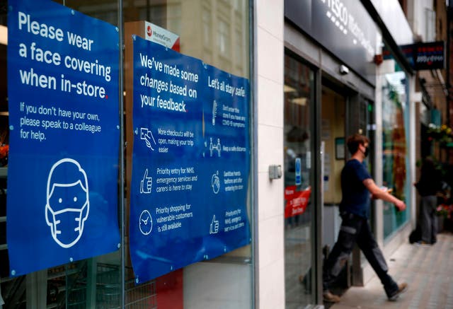 A Tesco store displays requests for shoppers to use face coverings