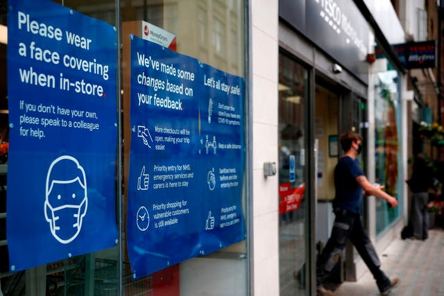 A Tesco store displays requests for shoppers to use face coverings