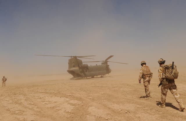 British soldiers walk to a military helicopter near the Pimon military camp in Nad-e Ali district of Helmand province, Afghanistan 