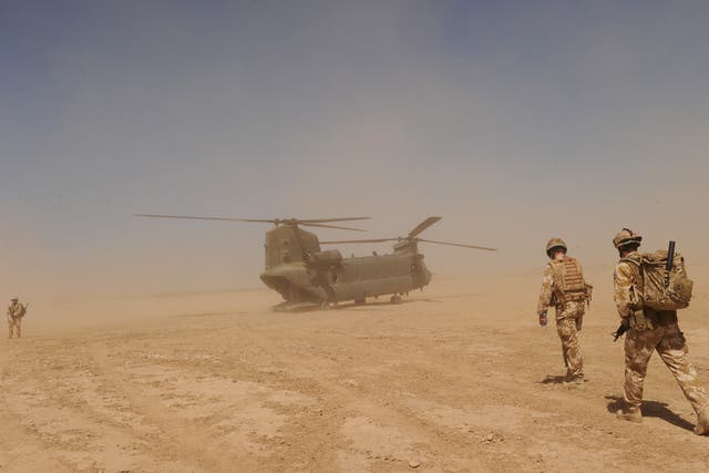 British soldiers walk to a military helicopter near the Pimon military camp in Nad-e Ali district of Helmand province, Afghanistan 