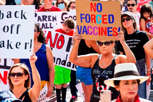 A woman with a QAnon shirt protesting a mandate from the Massachusetts Governor requiring all children, aged K-12, to receive a flu vaccine/shot to attend school for the 2020/2021 year outside the Massachusetts State House in Boston on August 30, 2020