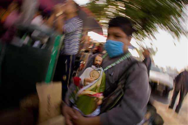 Un hombre sostiene una imagen de San Judas Tadeo, santo patrono de las causas imposibles, en Ciudad de México.