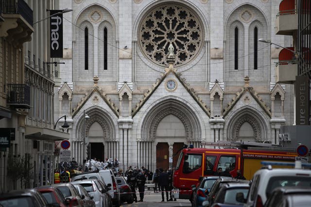 <p>French police and forensic officers stand in front of Notre Dame church after the attack</p>