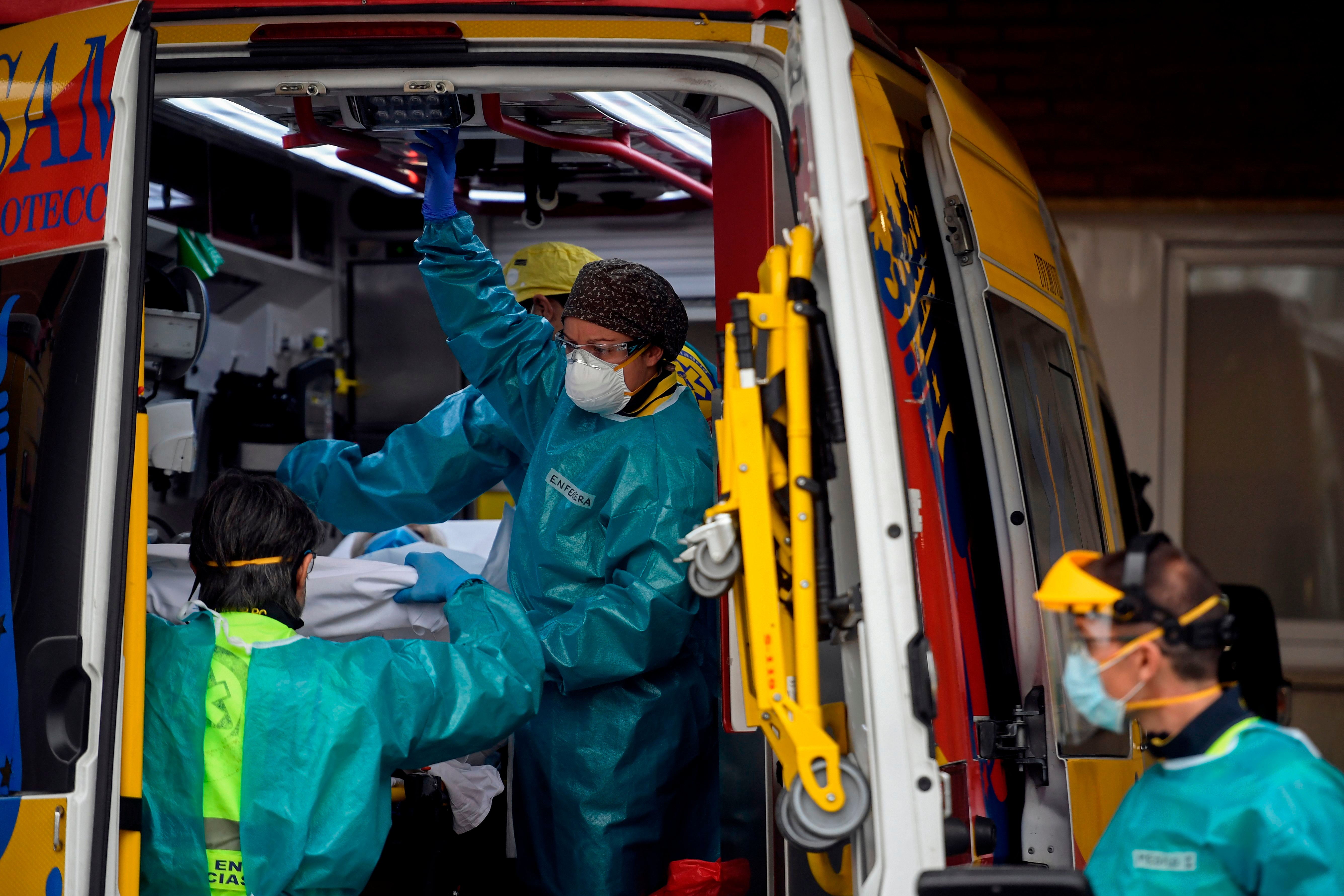 Healthcare workers take out a stretcher with a patient at University Hospital 12 de Octubre in Madrid