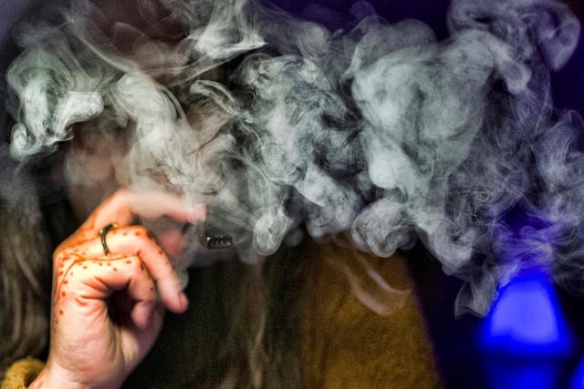 Mujer toma una bocanada de un vaporizador de cannabis en Los Ángeles