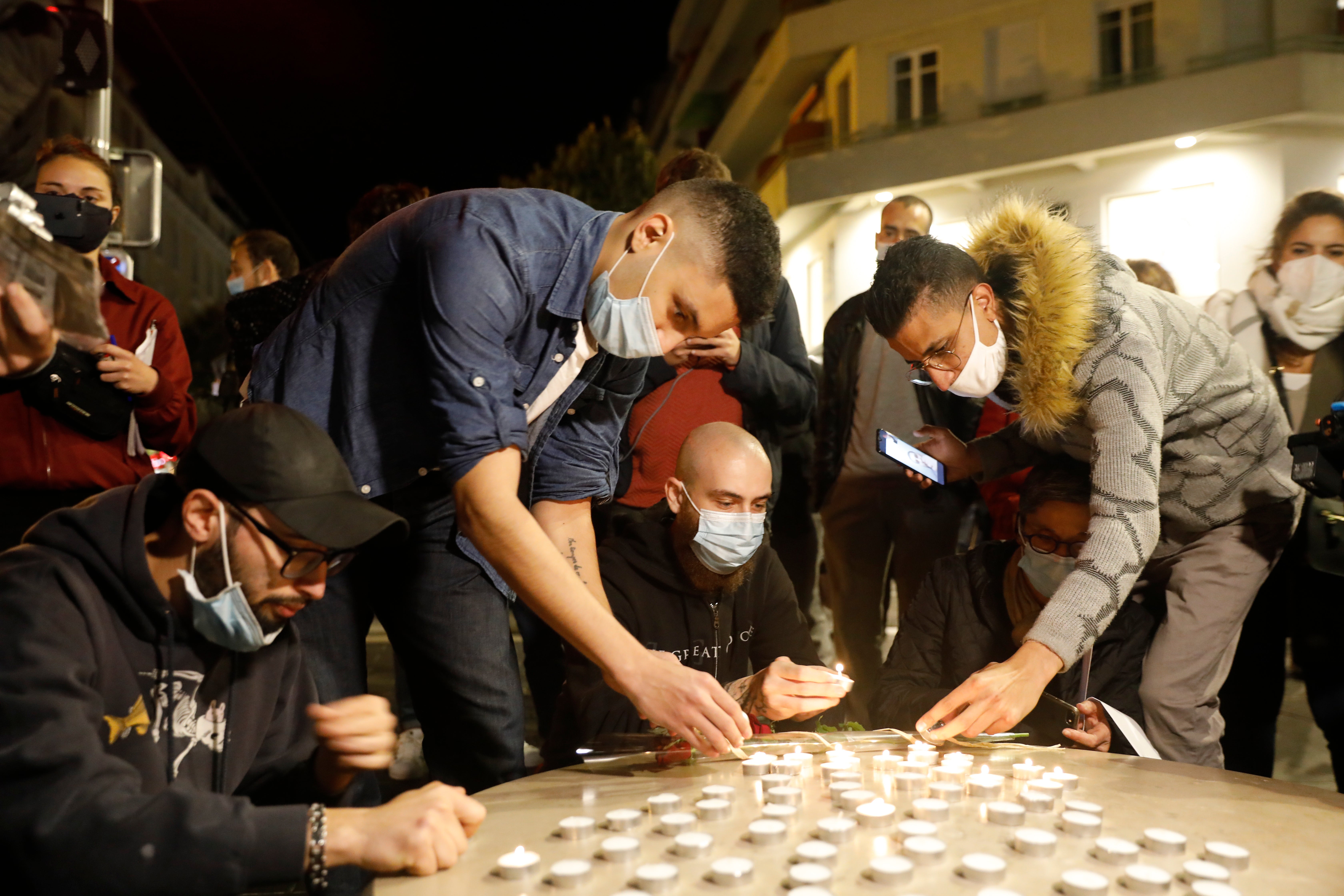 People light candles near the entrance of the Basilica of Notre Dame in Nice