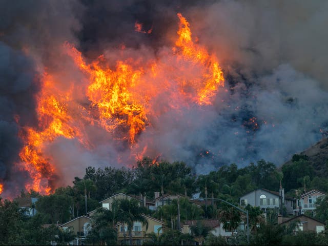 Flames rise near homes during the Blue Ridge wildfire on October 27, 2020 in Chino Hills, California. A new poll has found that the majority of Americans think we are running out of time to save the planet from the climate crisis