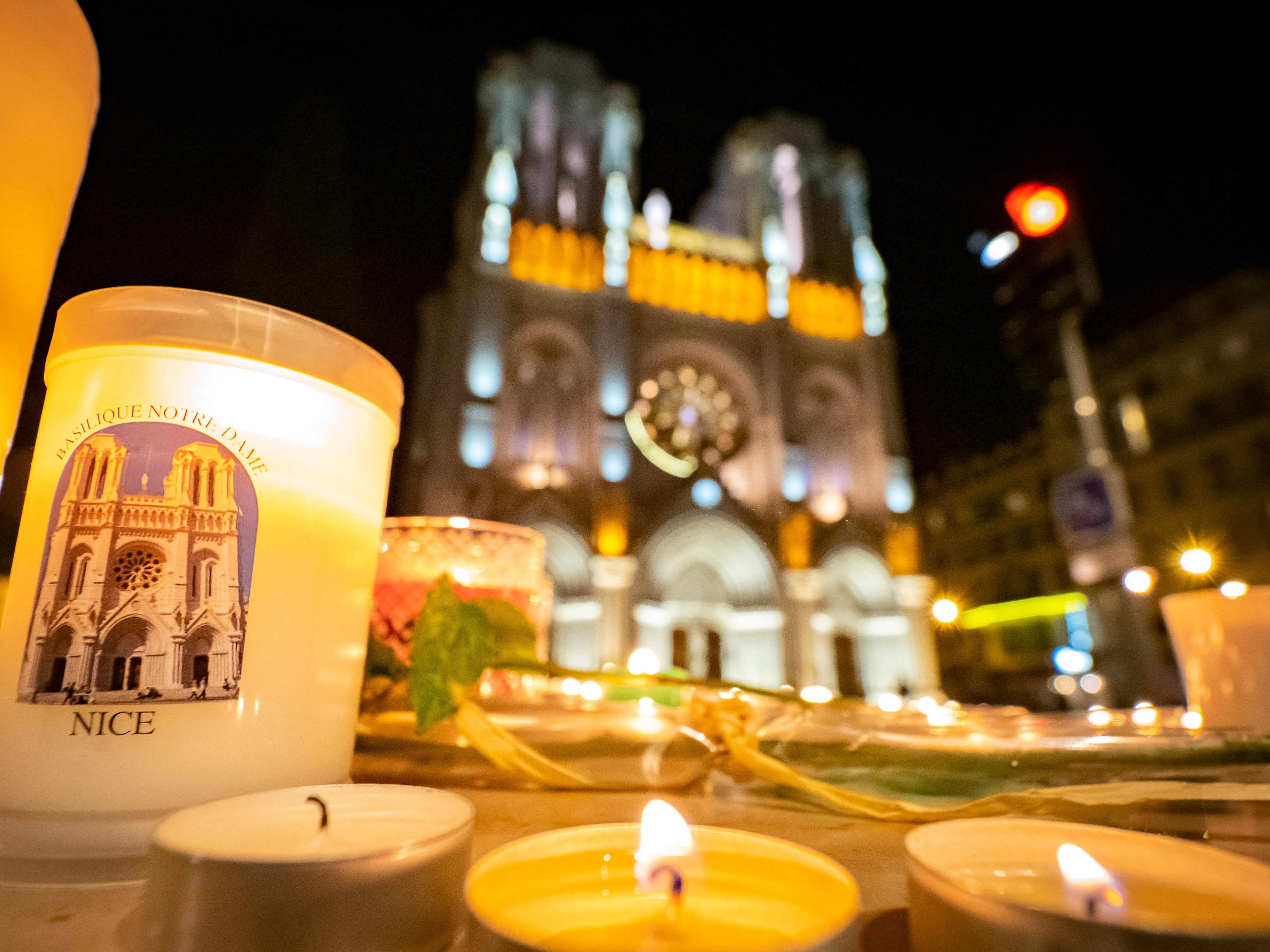 People pay tribute at night in front of Notre Dame Basilica on October 29, 2020 in Nice, France