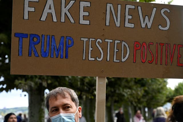 Un manifestante sostiene un cartel que dice "Noticias falsas".