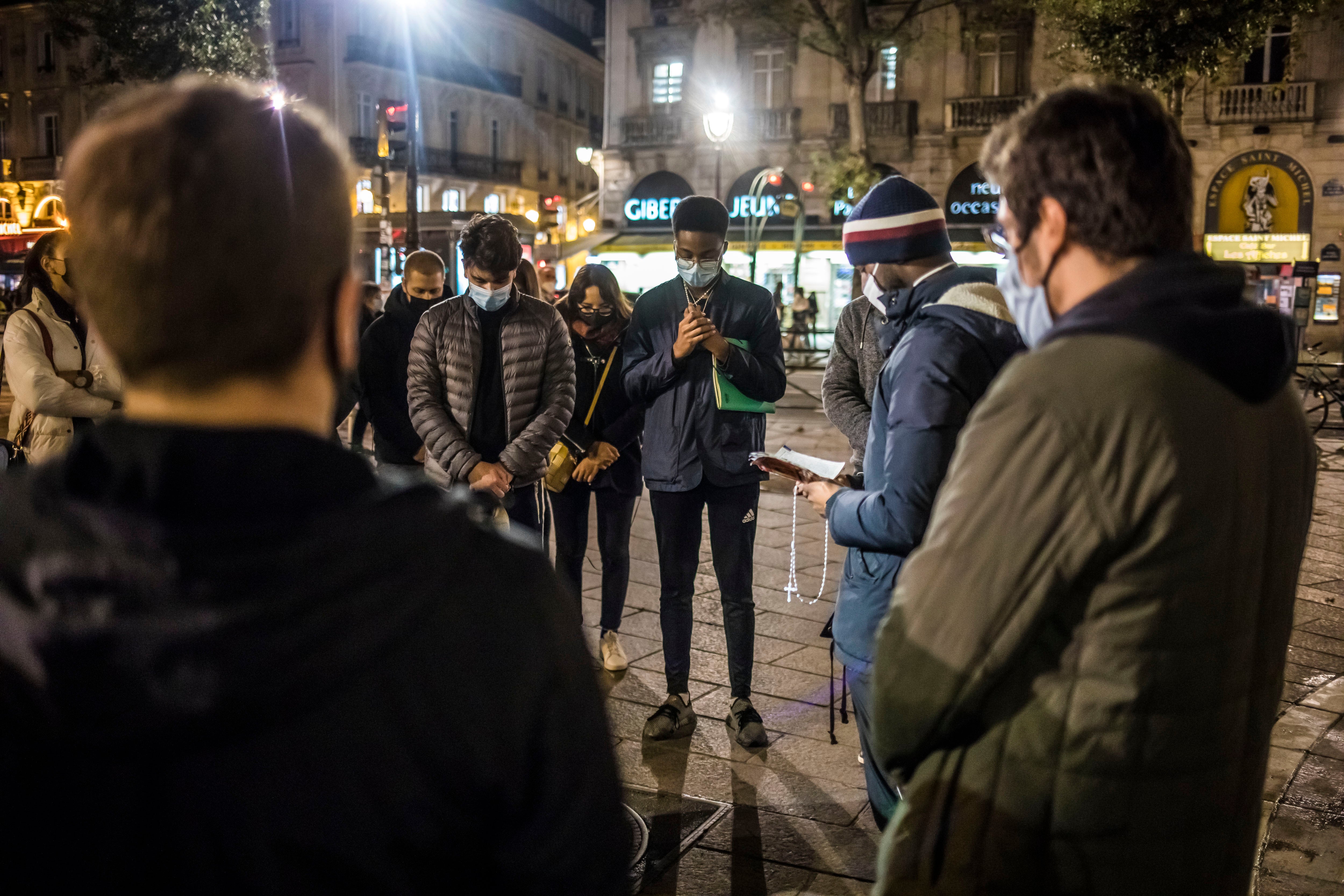 A group of young Catholics pray for the victims of the Nice attack, which took place yesterday, on the final evening of being allowed to gather outside